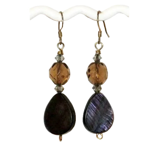 Pair of brown dangle earrings with teardrop-shaped shell beads on a white background