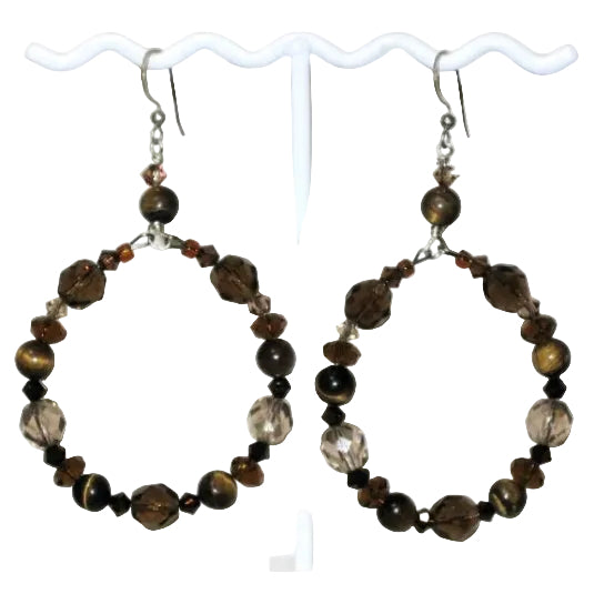 Pair of brown hoop earrings with tiger eye beads, crystals and faceted glass beads on a white stand.