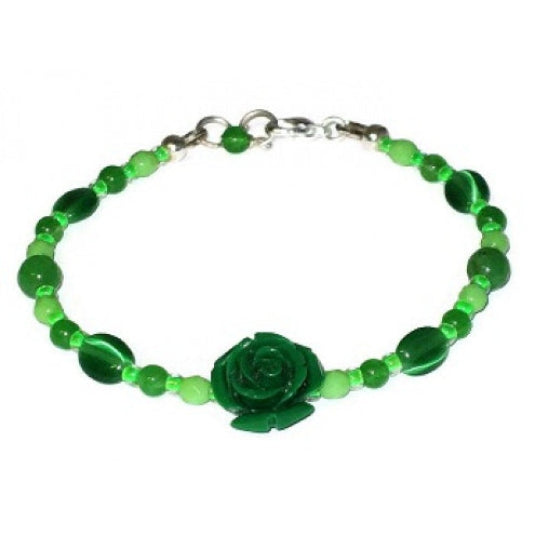Delicate green beaded bracelet with a carved flower bead in the center on a white background