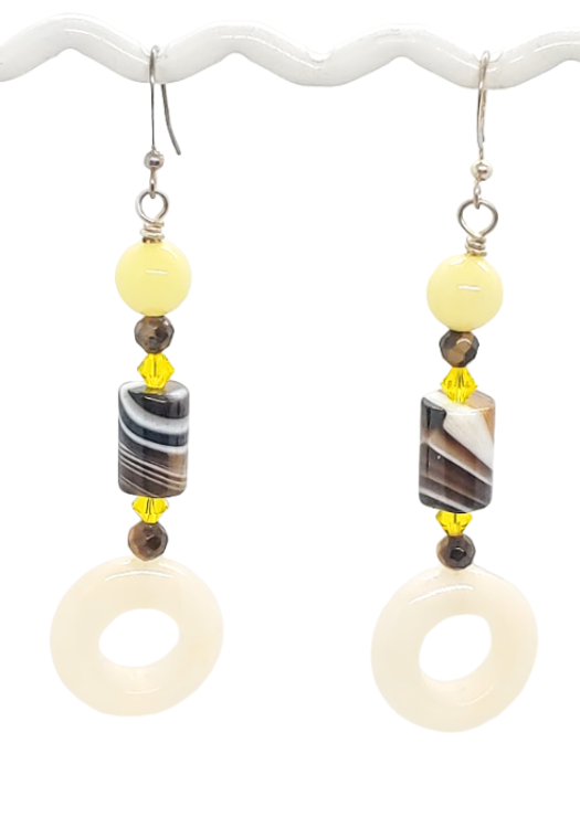 Pair of earrings with yellow, brown, and white gemstone beads and crystals on a white background
