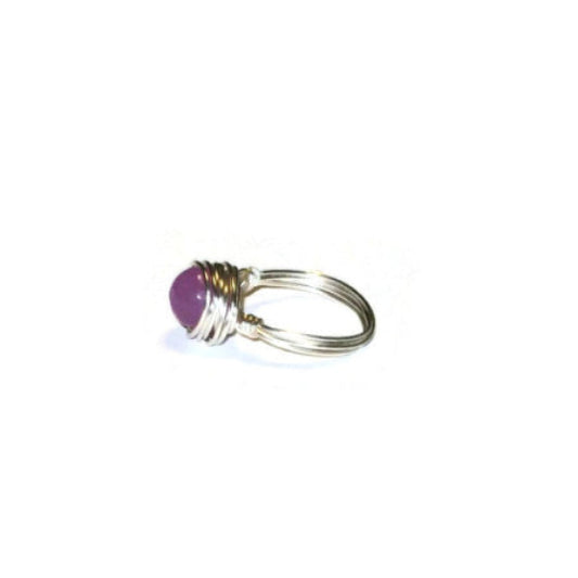 Side view of a orchid purple wire-wrapped ring featuring a jade-style-gemstone bead wrapped in silver-plated wire