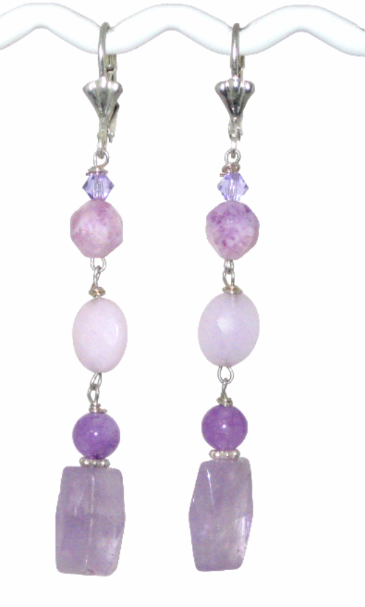 Pair of earrings with purple gemstone beads and crystals on a white background