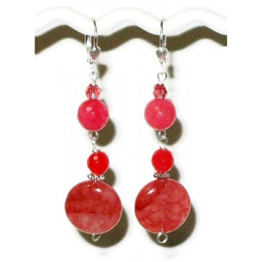 Pair of deep pink raspberry watermelon colored dangle earrings on a white background