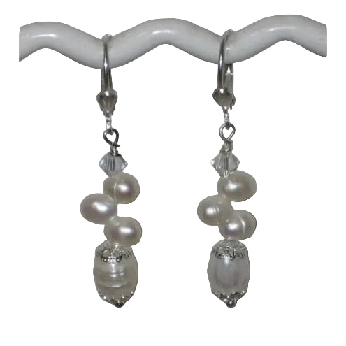 Pearl and crystal drop earrings on a white stand.