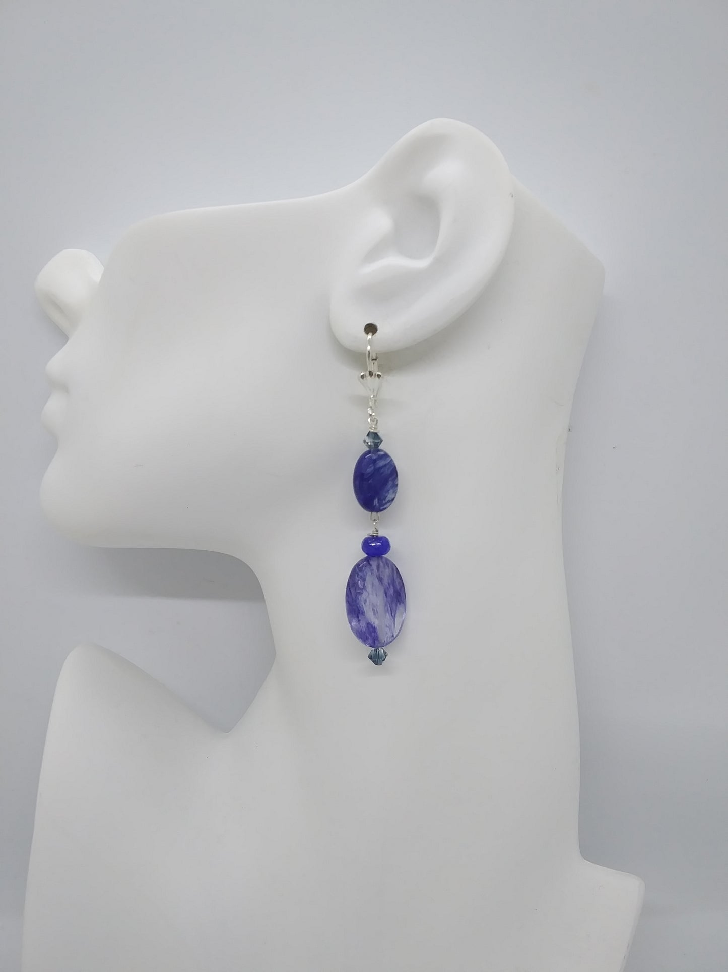 Earring with blue beads on a white ear mannequin model