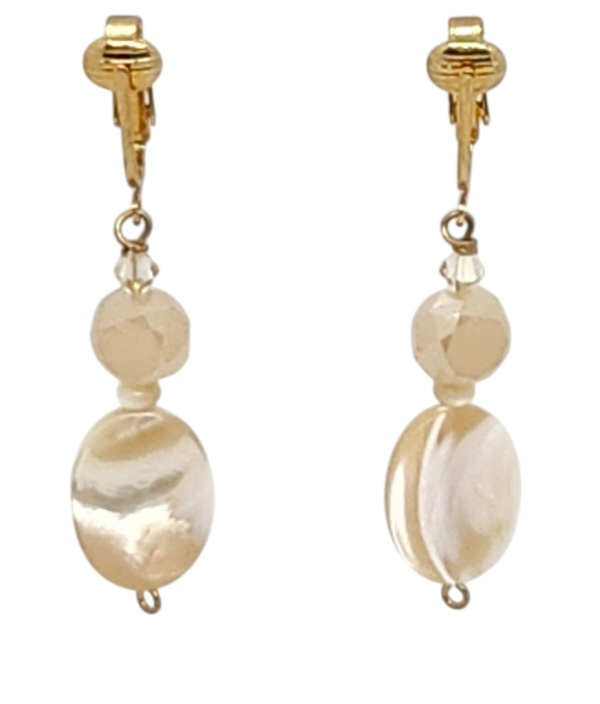 A pair of gold-tone clip-on dangle earrings featuring faceted round beads and larger oval mother-of-pearl beads, shown against a plain white background.