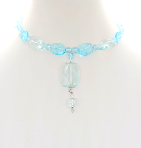 Choker with aqua blue beads and a center drop pendant on a light background