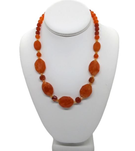 Necklace with orange carnelian and jade-style gemstone beads on a white mannequin bust