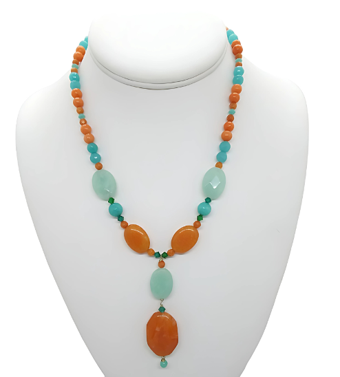Necklace with orange and turquoise beads on a white mannequin