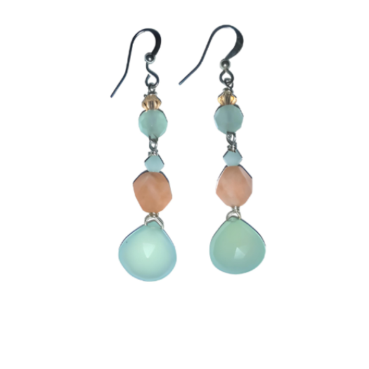 Pair of dangle earrings with light green and peach beads on a white background