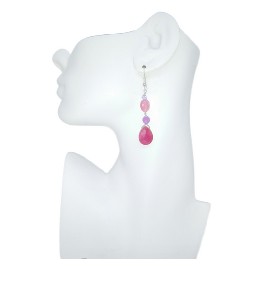 Earring with pink and purple beads on a white mannequin ear