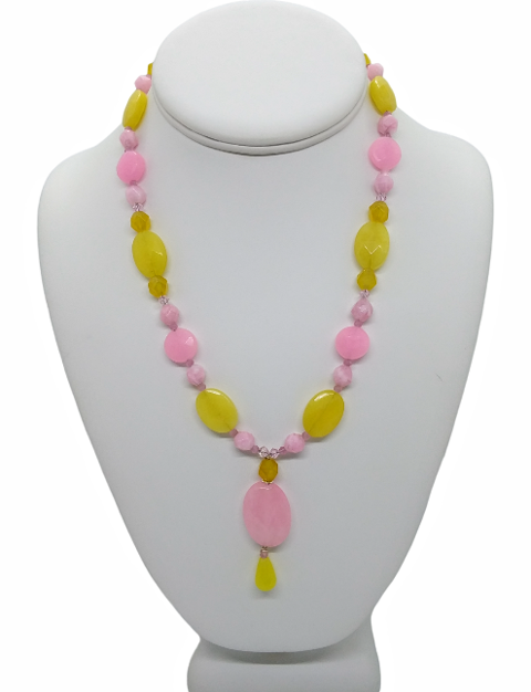 Necklace with pink and yellow beads on a mannequin bust against a white background