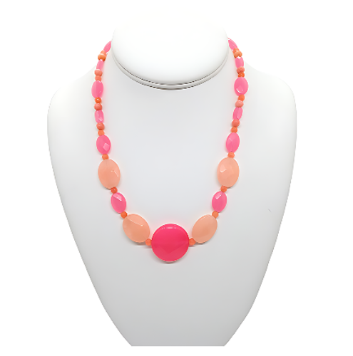 Necklace with pink and peach beads on a white mannequin bust