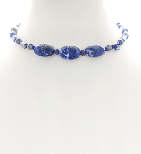Navy blue choker style necklace with white beads on a white background