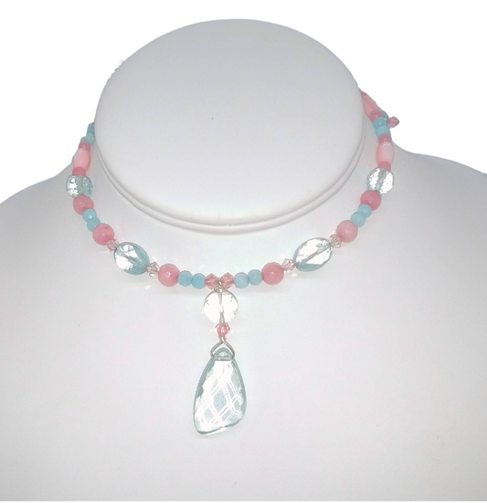 A delicate beaded blush pastel pink and aqua choker displayed on a white mannequin bust. It features pastel pink and light blue and aqua quartz beads, clear faceted round beads, and a faceted aqua quartz teardrop-shaped pendant.