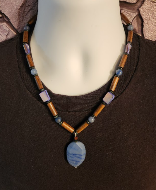 A brown, denim blue and navy blue men's beaded necklace with wood, shell, and lapis beads. and a rugged denim blue pendant.
