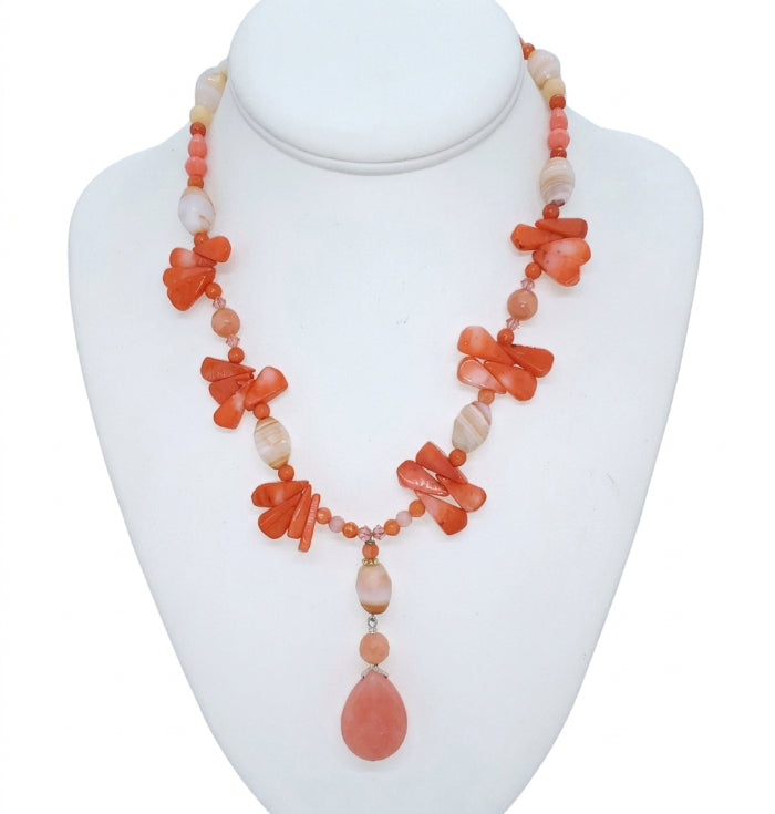 Handcrafted coral and cream-colored  gemstone beaded statement necklace with a drop pendant
