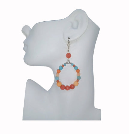 Colorful coral, peach and light blue hoop earring with Jade beads, crystal accents and silver-plated leverbacks on a white mannequin ear