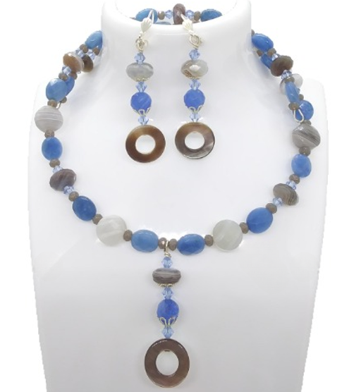 Choker and earrings with blue, brown, and gray beads on a white stand


