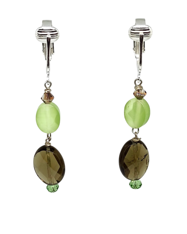 A pair of clip-on dangle earrings featuring a light green oval bead, a small faceted brown crystal, and a larger brown oval faceted bead with a tiny green accent bead at the bottom.