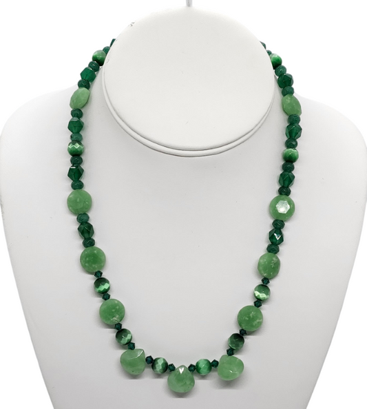 A light and dark green beaded necklace displayed on a white mannequin bust against a white background.