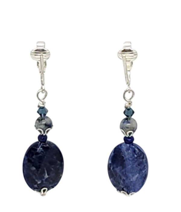 A pair of navy blue and bluish gray clip-on earrings featuring large oval navy blue semi-precious stones, accented with smaller semi-precious stones and crystals.