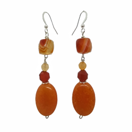 Pair of earrings with orange and red beads on a white background