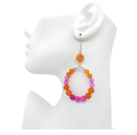 pink and orange hoop earrings on mannequin ear 