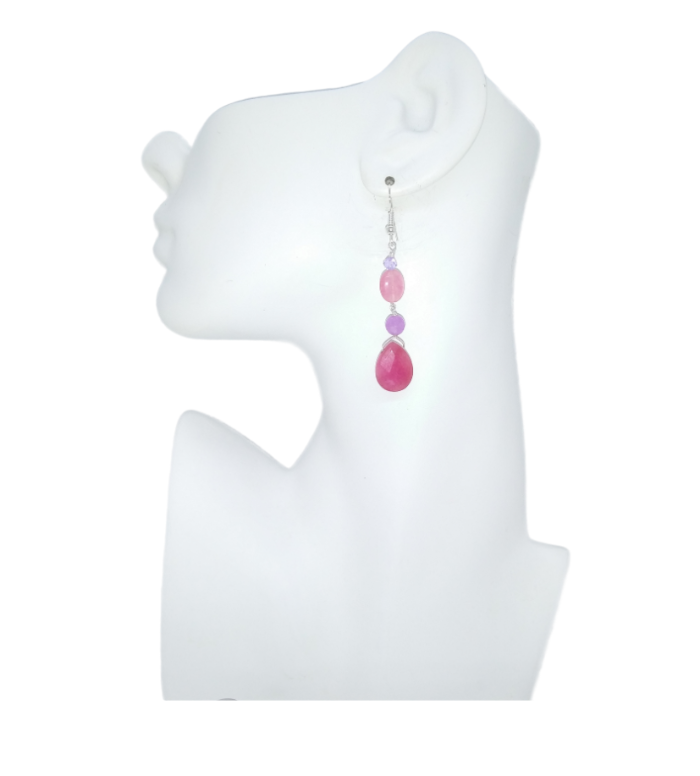 Earring with pink and purple beads on a white mannequin ear