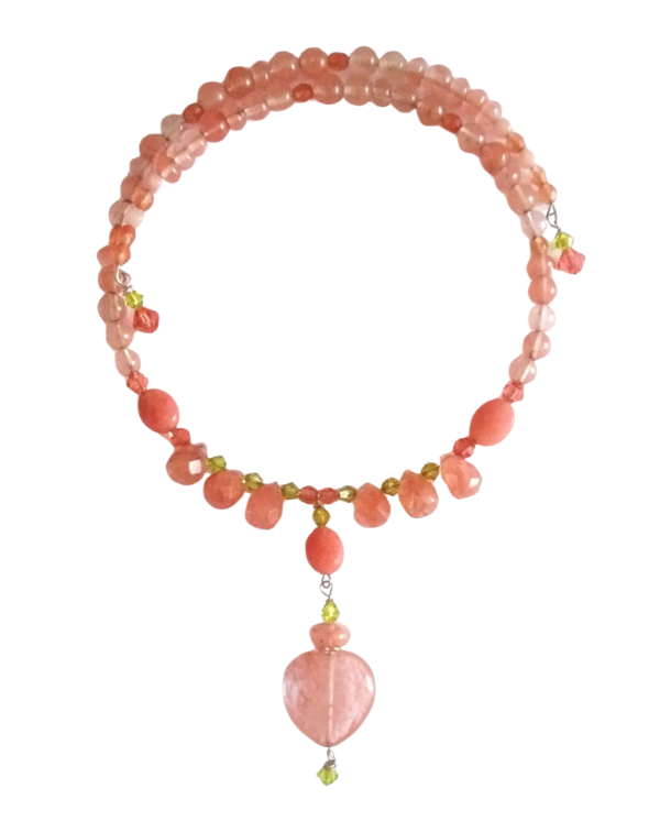 A beaded expandable choker made of  cherry quartz beads and jade-style gemstone beads with small  peridot-colored green sparkling crystals. Showcasing a drop pendant with a cherry quartz heart shown on a plain white background.