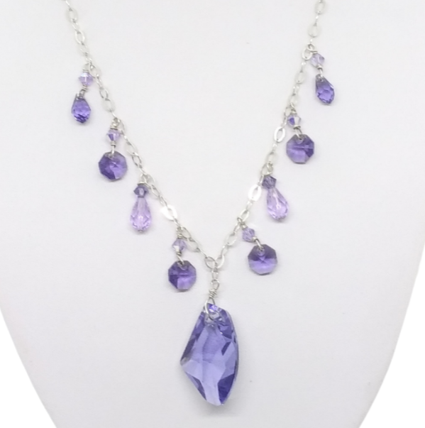 Close up of purple crystal sterling silver necklace on a white necklace display