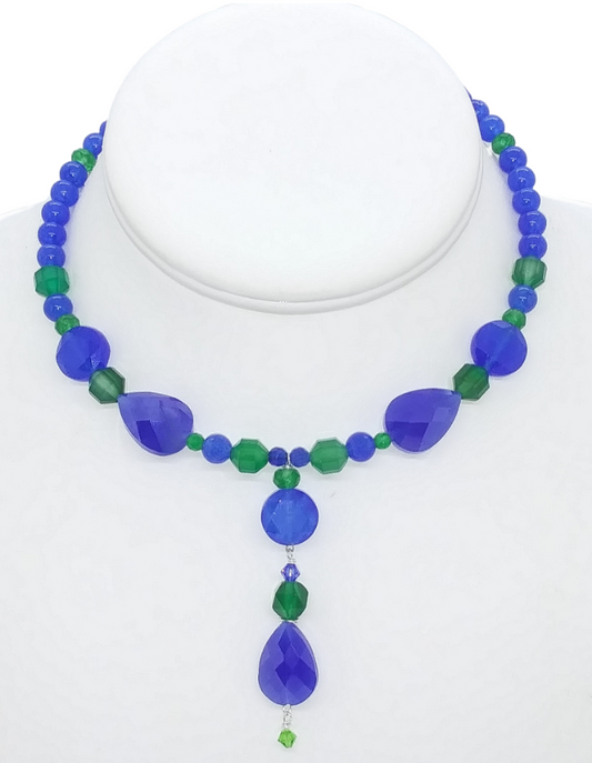 Handmade royal blue and emerald green gemstone choker with a 2 ½-inch drop pendant featuring a faceted royal blue teardrop bead, dyed jade-style gemstone beads, agate beads, and crystal accents.
