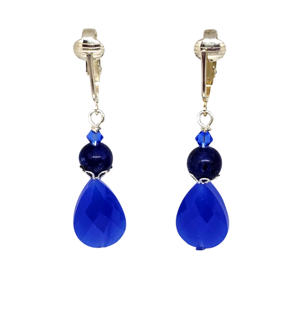 A pair of drop clip-on earrings with pierced-look ear clips and a small faceted blue crystal, a navy blue bead, and a large faceted royal blue teardrop bead, shown on a plain white background.