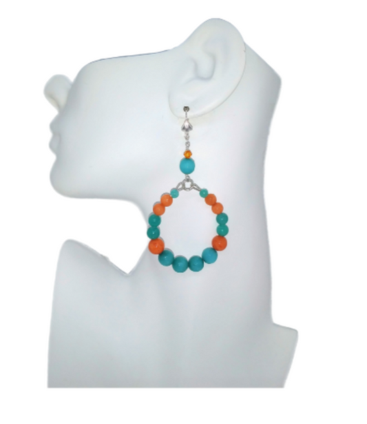 Earring with teal and orange beads on a white mannequin ear